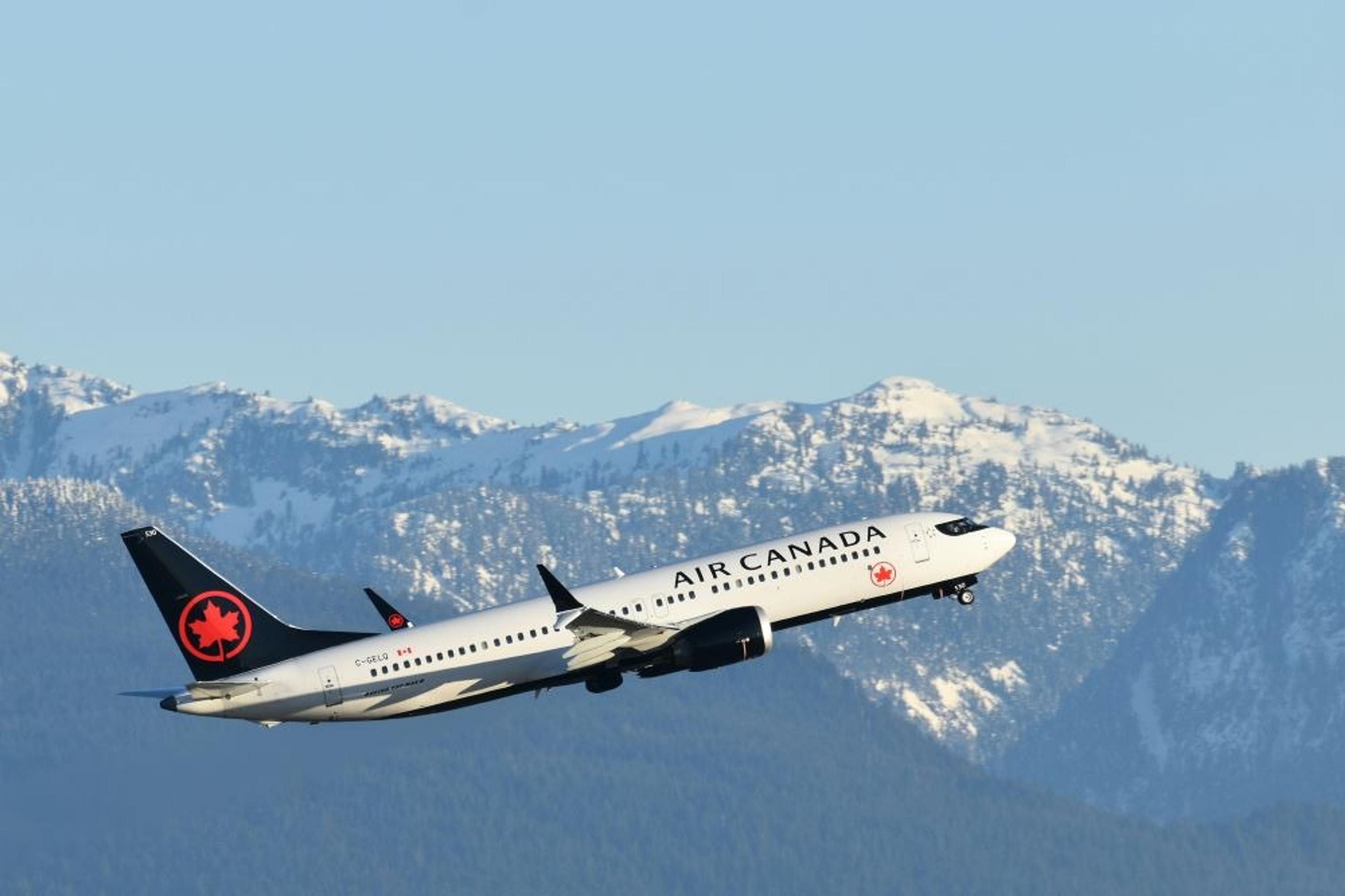 Air Canada plane taking off in front of mountains