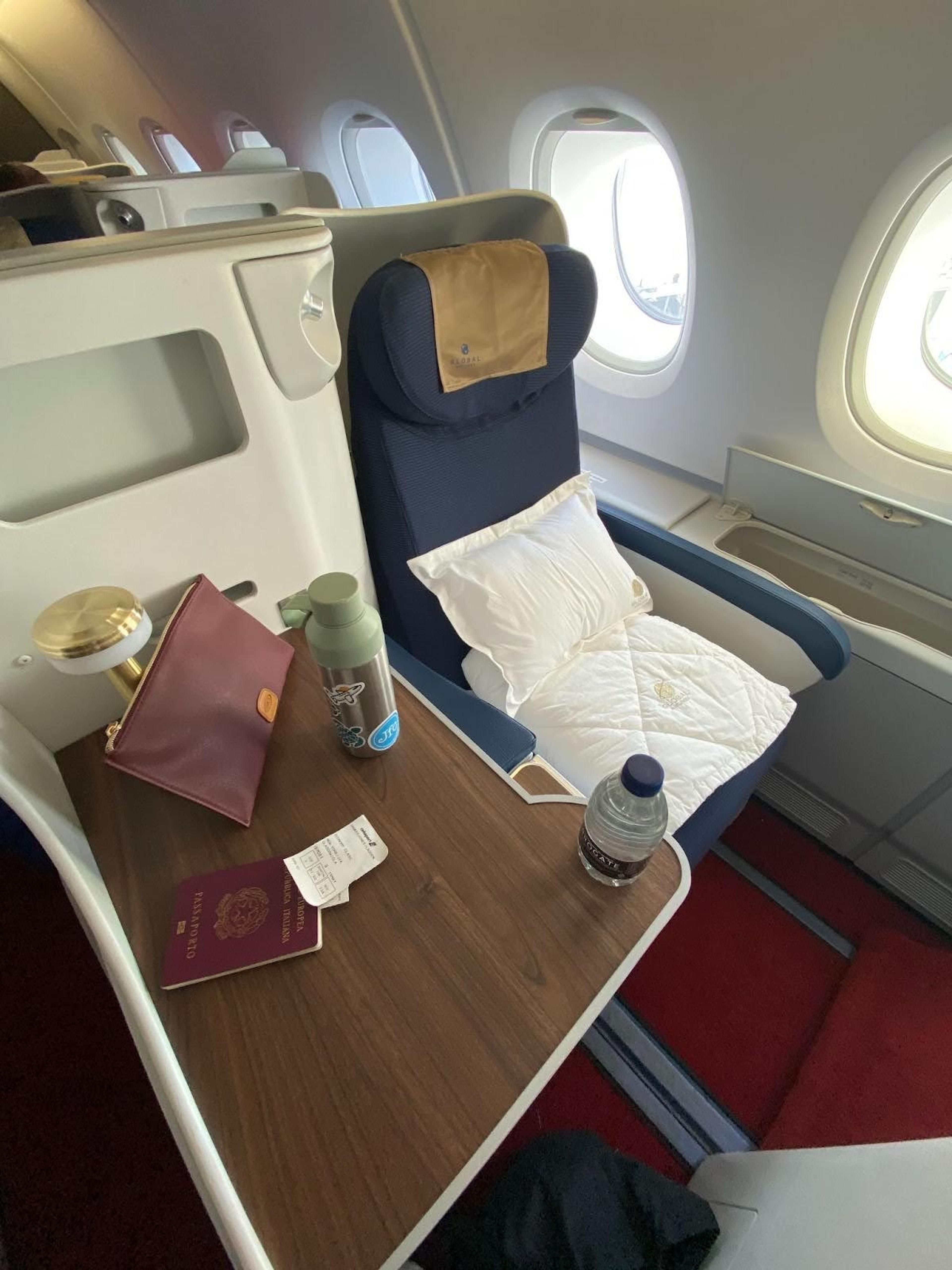Single navy blue business class seat with side table