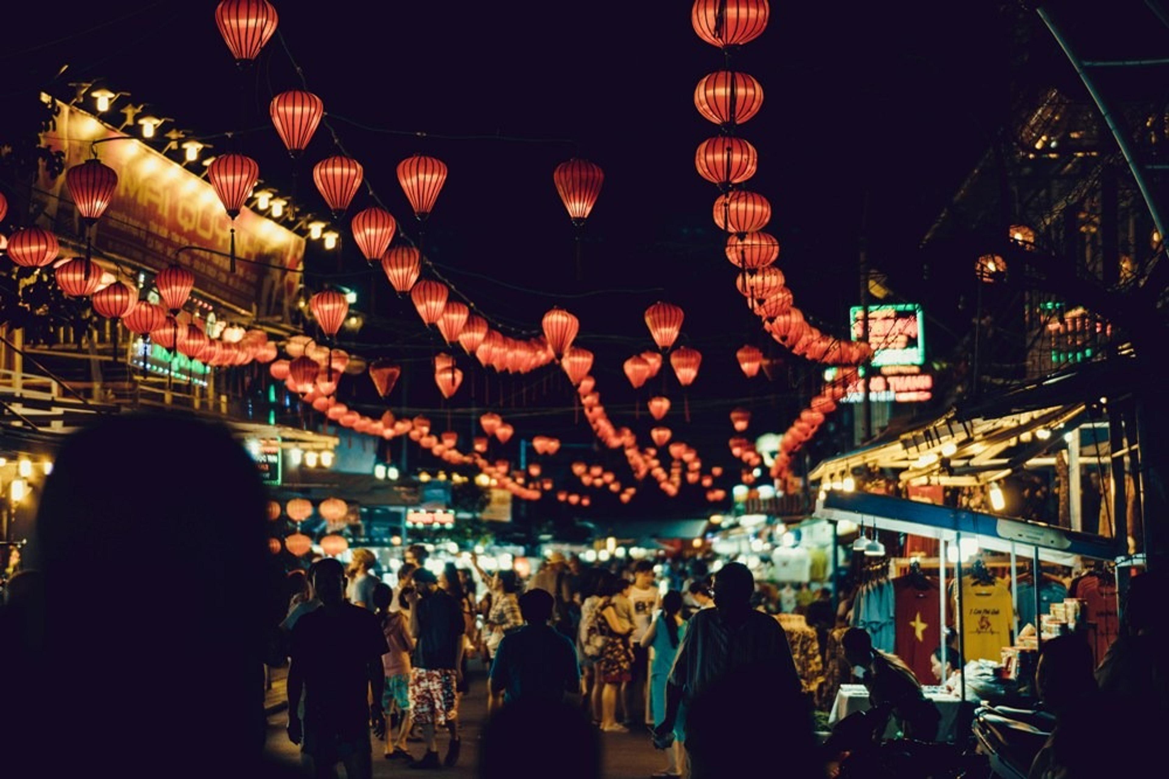 Lanterns hanging above a street at nighttime