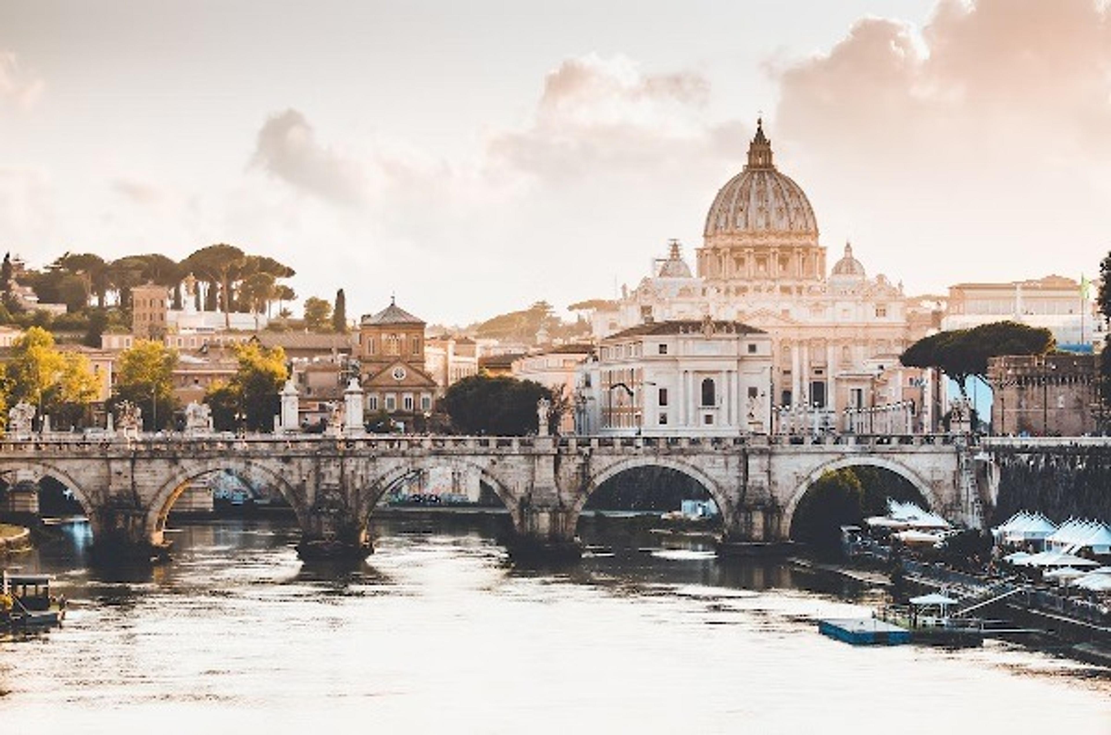 View of bridge over a river with Roman buildings in the background