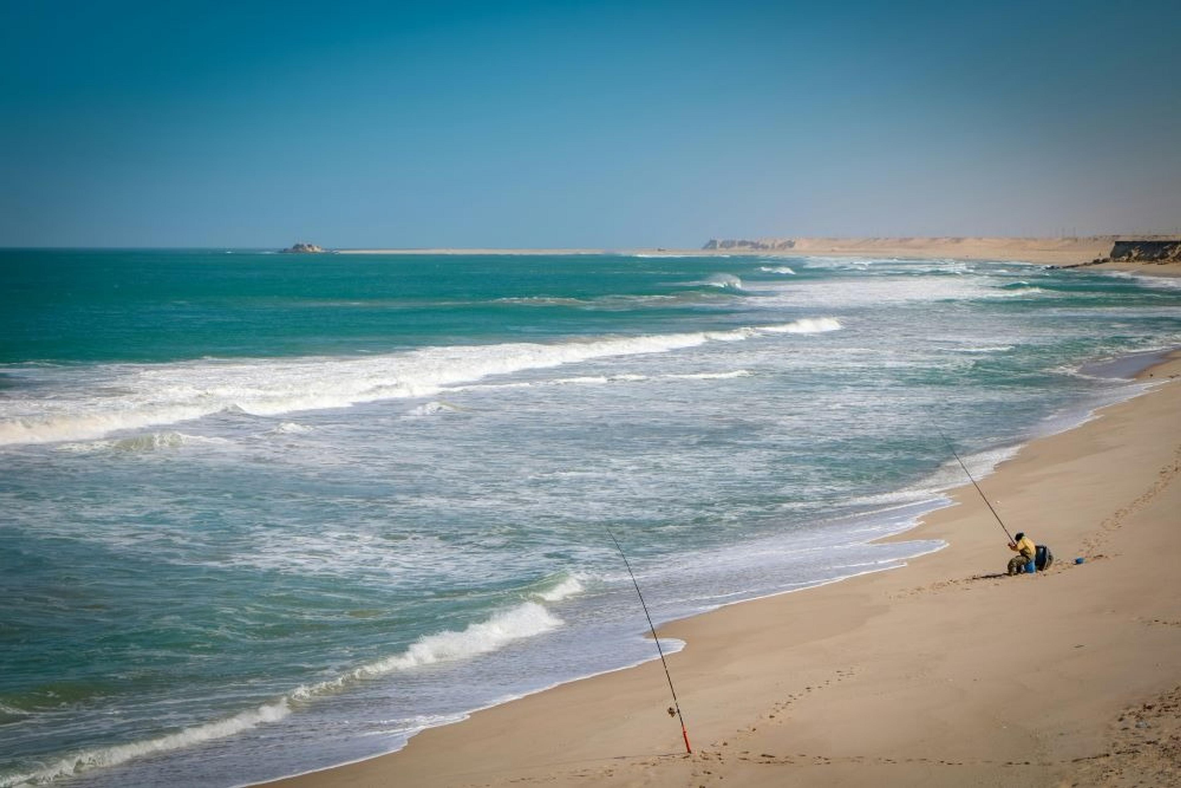 Man fishing on a sandy beach
