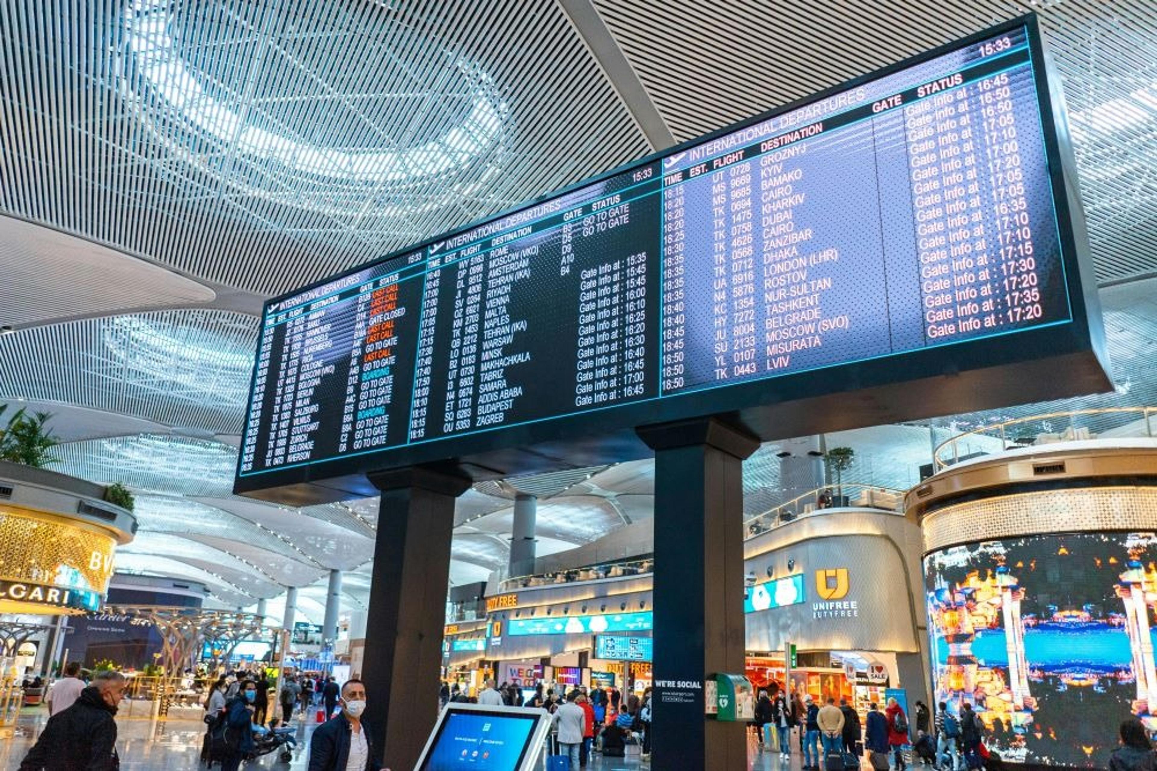Departures board and busy shops in Istanbul Airport